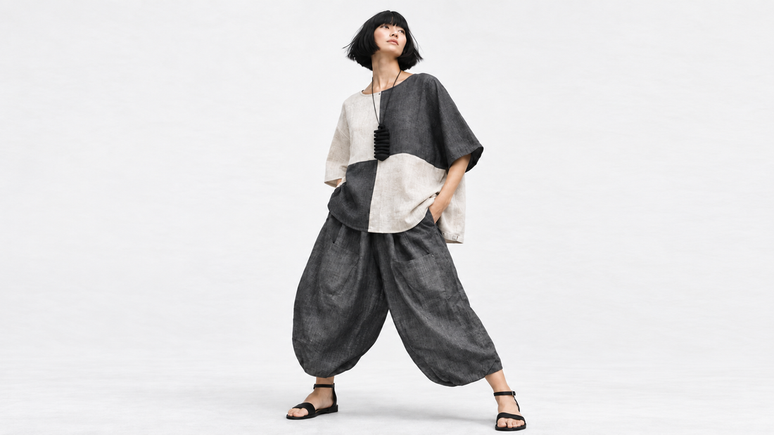 Model wearing a colour-block linen top with charcoal Samurai pants against a soft white studio background.