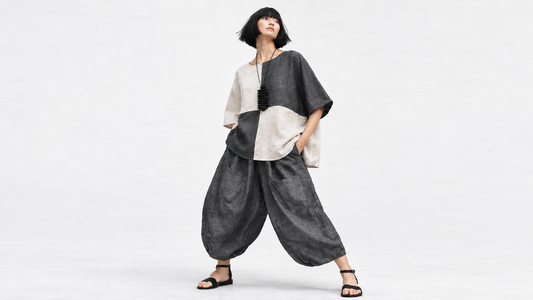 Model wearing a colour-block linen top with charcoal Samurai pants against a soft white studio background.