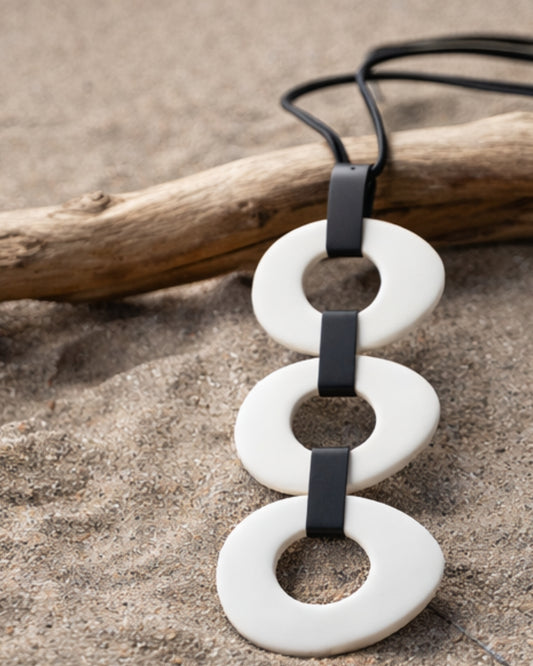 Jen Kahn 3 disc elliptical pendant in white with resin discs on leather cord
