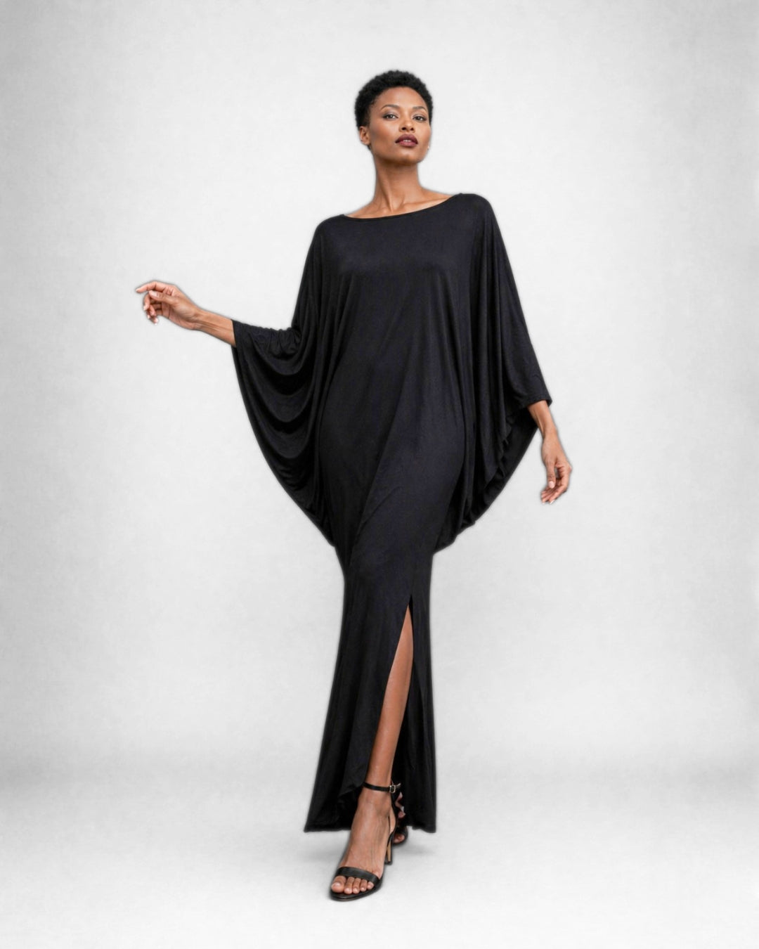 Jen Kahn Batwing Dress in Black jersey knit with a fluid draped upper body, streamlined lower shape, asymmetric hem and front slit.