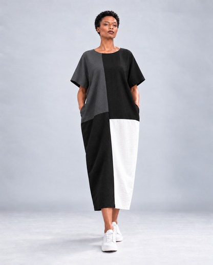 Front view of the Jen Kahn Blocked Linen Dress in black, charcoal grey and white, with short sleeves and hands in side-seam pockets.