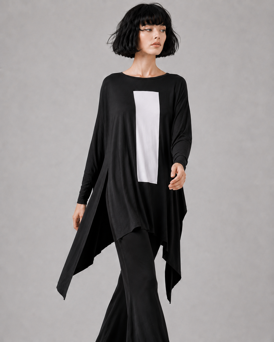 jen kahn Column Jersey Knit Top in Black with white column print, featuring an asymmetric draped hem and side slits, styled with black flared jersey pants.