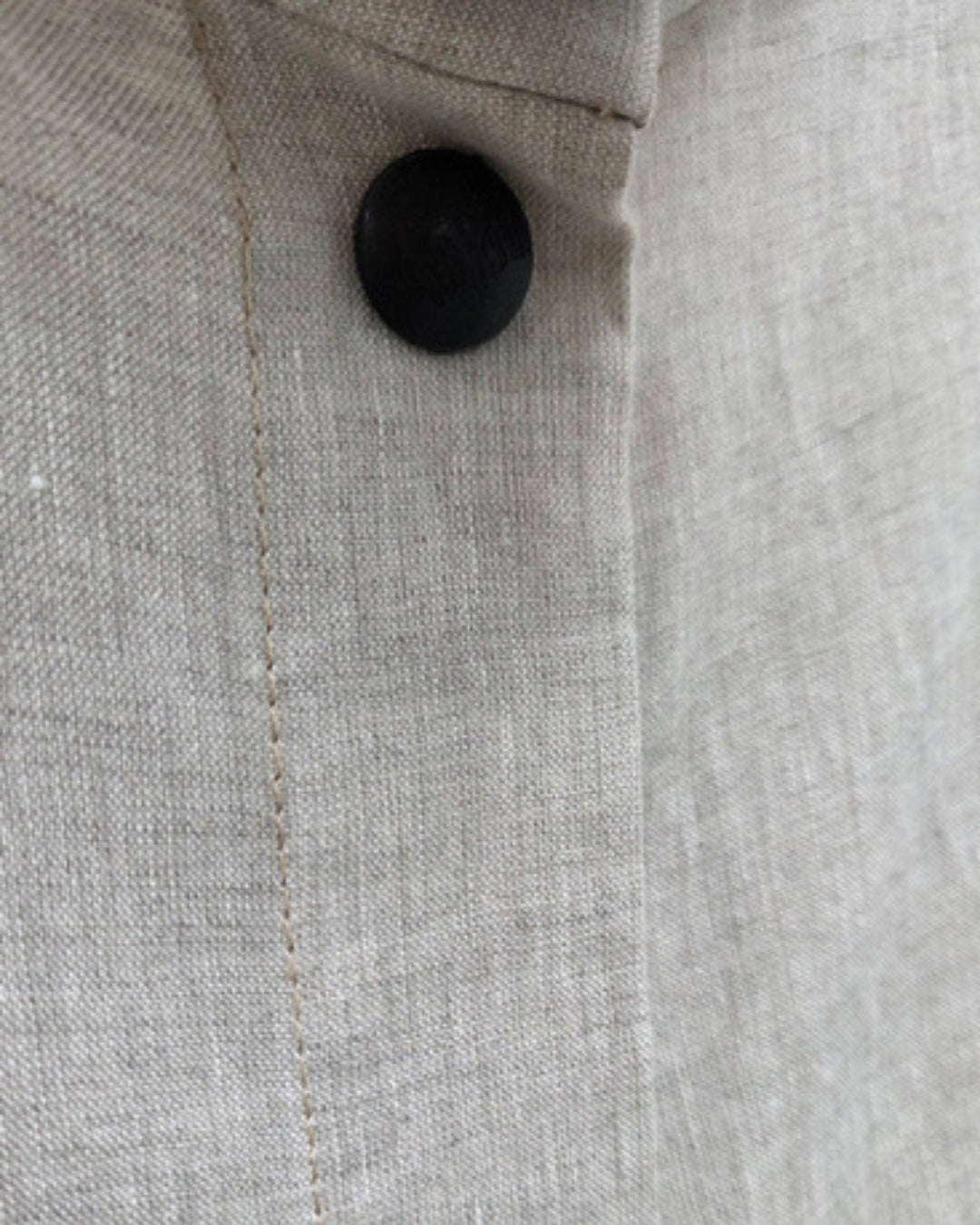 Close-up of the Jen Kahn High Collar Linen Shirt showing a black stud, stitched placket and linen texture.