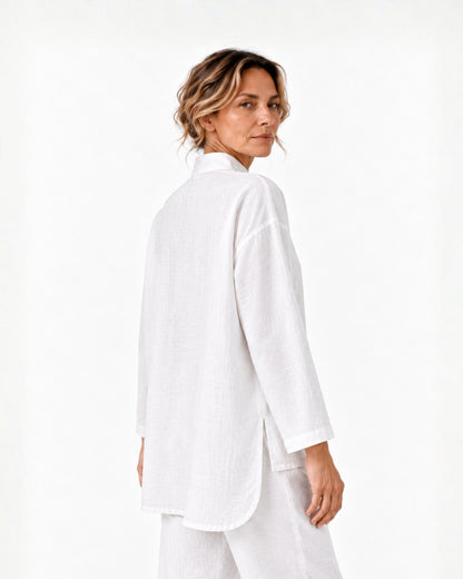 Three-quarter back view of a model wearing the white Jen Kahn High Collar Linen Shirt, showing the plain back, long sleeves, side slit and longer back hem.