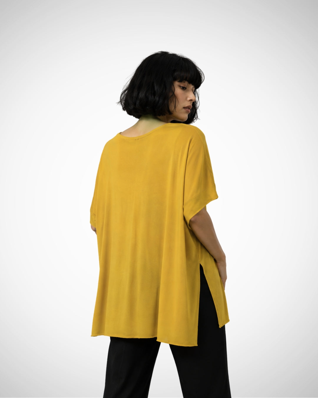 Back view of Jen Kahn Linear Jersey Knit Top in Ochre showing relaxed draped fit and side slits