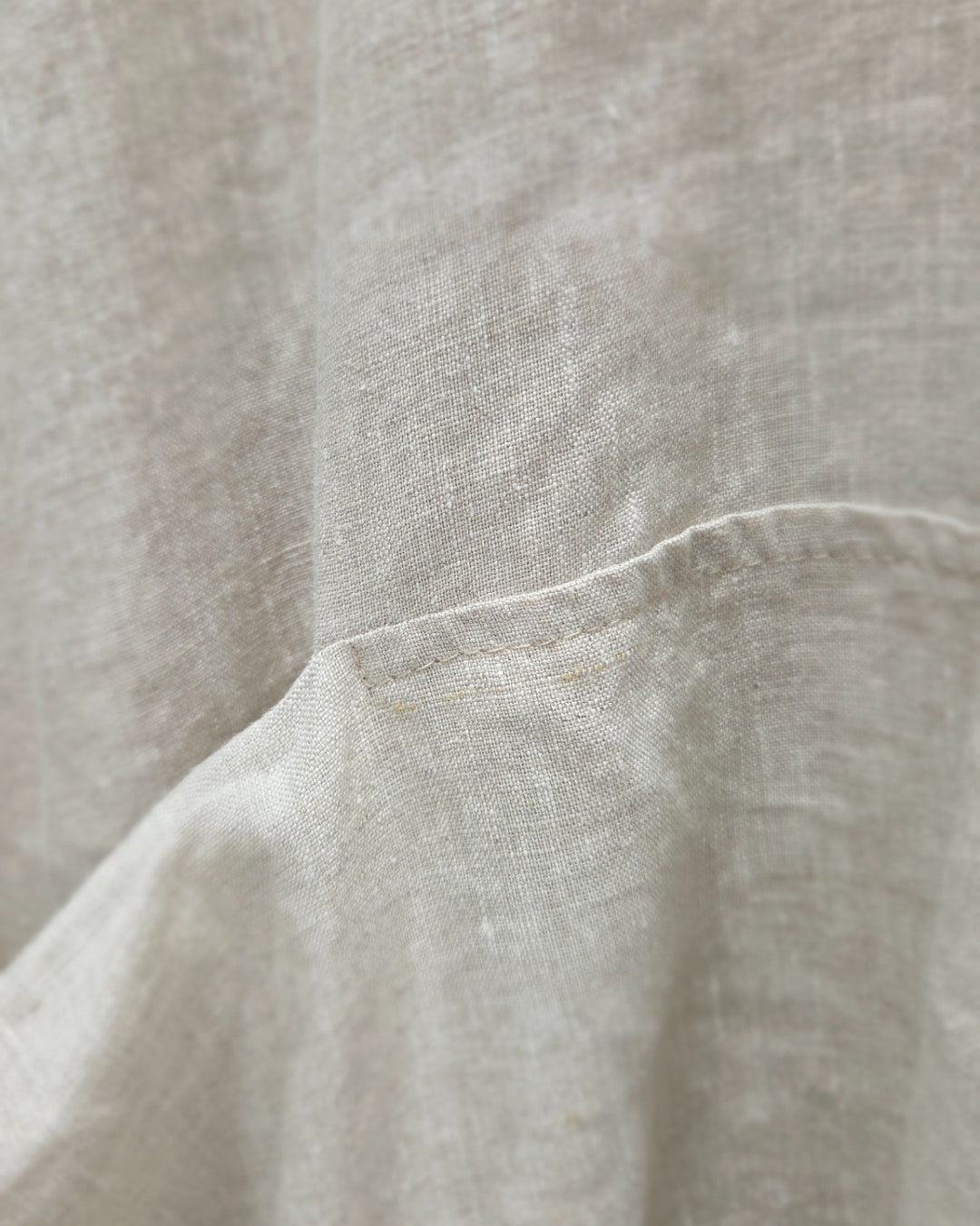 Close-up of the jen kahn Linen Pocket Top in Natural, showing the seam-set pocket opening and linen texture.