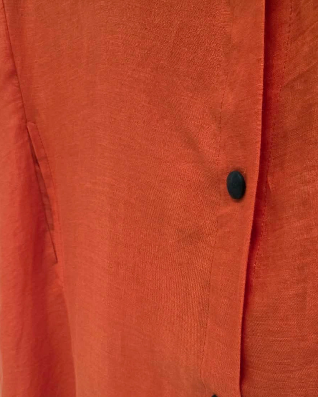 Close-up of the Jen Kahn Long Linen Shirt Dress in Tangerine, showing the natural linen texture, black button and stitched front placket.