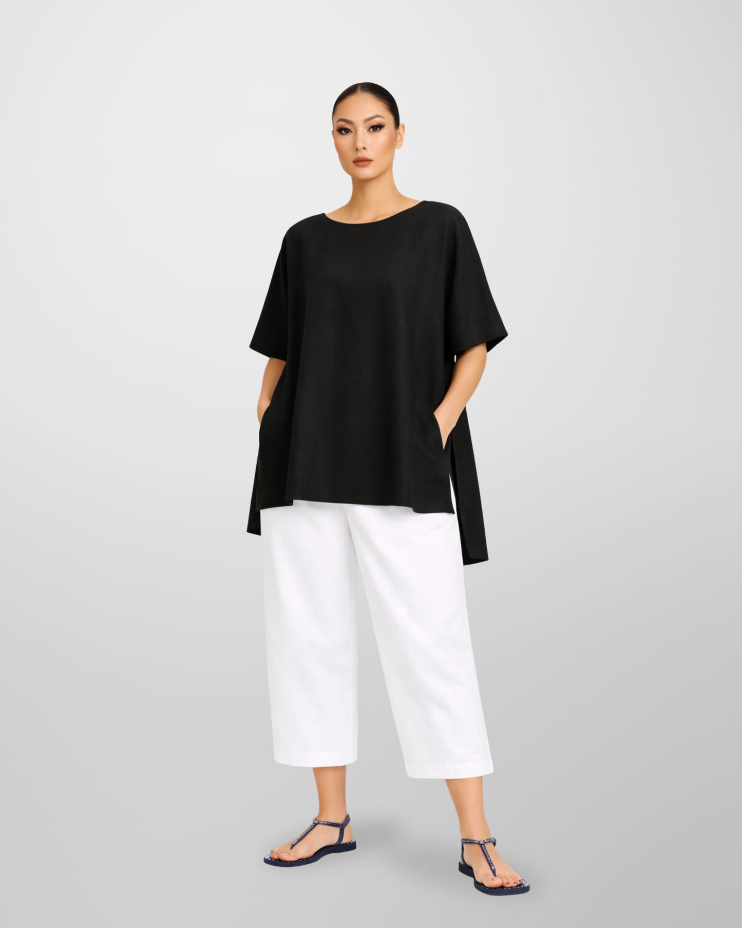 Jen Kahn Long Tokyo linen tunic in black worn on model with short sleeves, hidden seam pockets and longer back hem