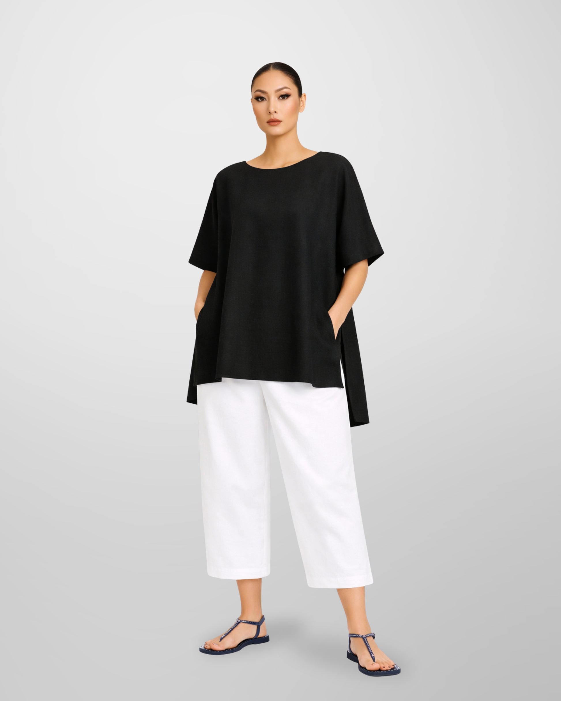 Jen Kahn Long Tokyo linen tunic in black worn on model with short sleeves, hidden seam pockets and longer back hem