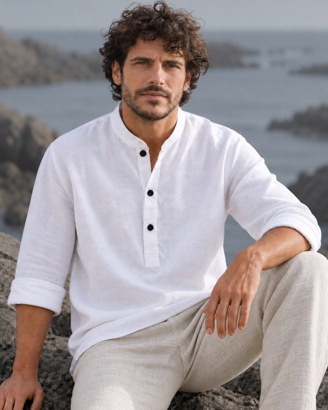 Man wearing the Jen Kahn white Mandarin Half Button Linen Shirt by the coast.