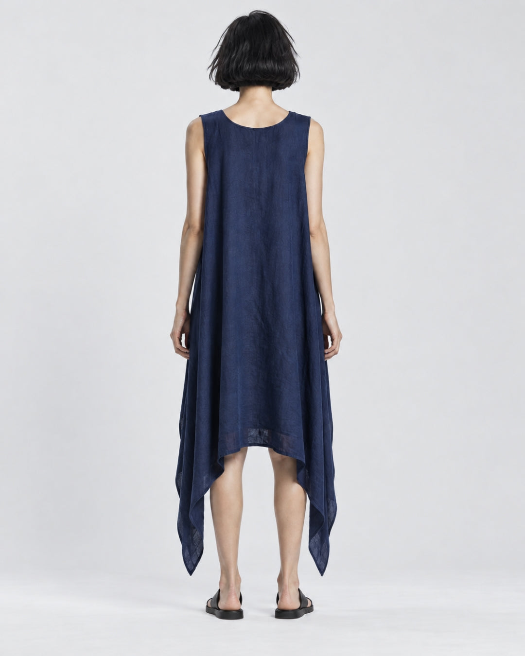 Back view of the Jen Kahn Riviera Dress in Indigo, long version, showing the rounded neckline, relaxed straight drape and softly falling asymmetric side points.