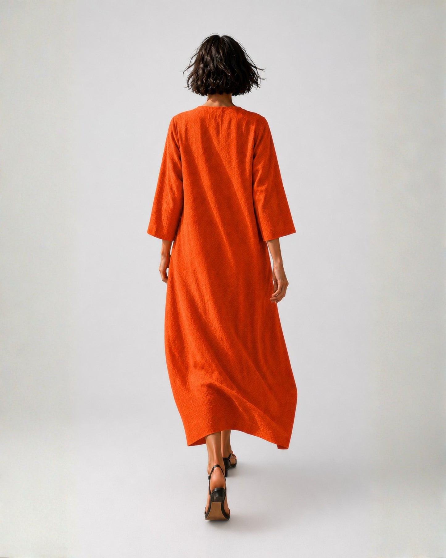 Back view of the jen kahn Tokyo Linen Dress in Tangerine made from pure linen with a relaxed bell-shaped silhouette, three-quarter sleeves and wide lower panel detail.