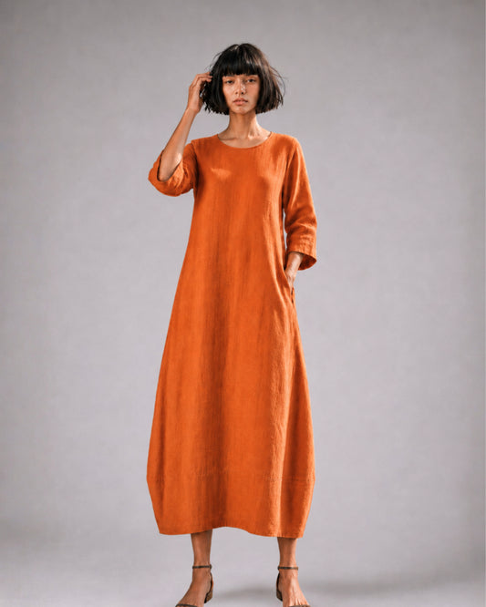jen kahn Tokyo Linen Dress in Tangerine made from pure linen with a relaxed bell-shaped silhouette, round neckline, three-quarter sleeves and hidden seam pockets.