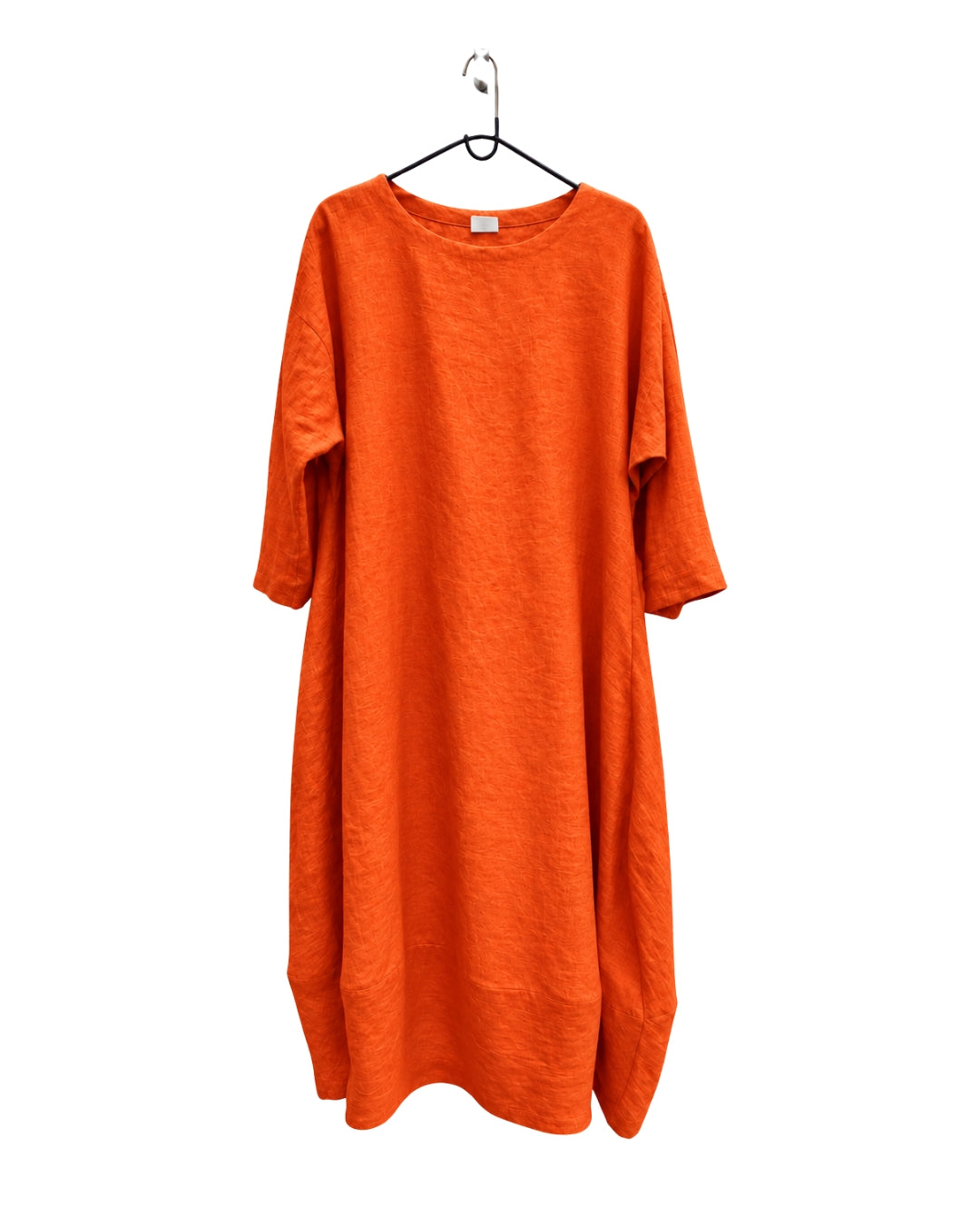Jen Kahn Tokyo linen dress in tangerine on a hanger, with three-quarter sleeves and a softly tapered hem.