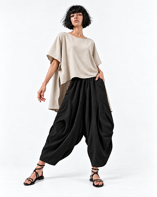 Model wearing the jen kahn Tokyo Linen Top in Natural with black Samurai Linen Pants, showing a shorter front and softly draped longer back with a visible side slit.
