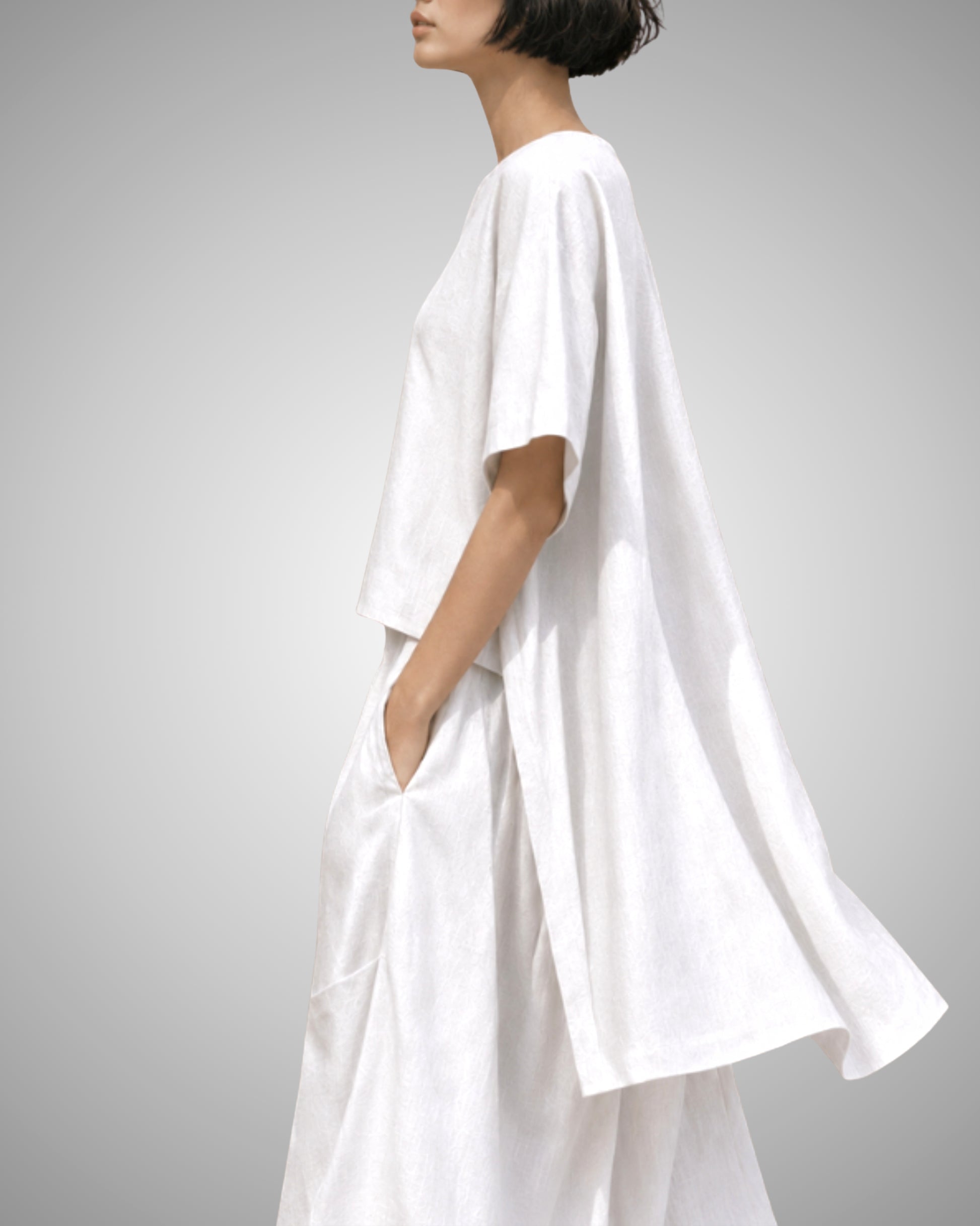 Jen Kahn Tokyo Linen Top in White pure linen shown from the side, featuring a relaxed box-cut silhouette with a shorter front, longer back and flowing asymmetric hem.